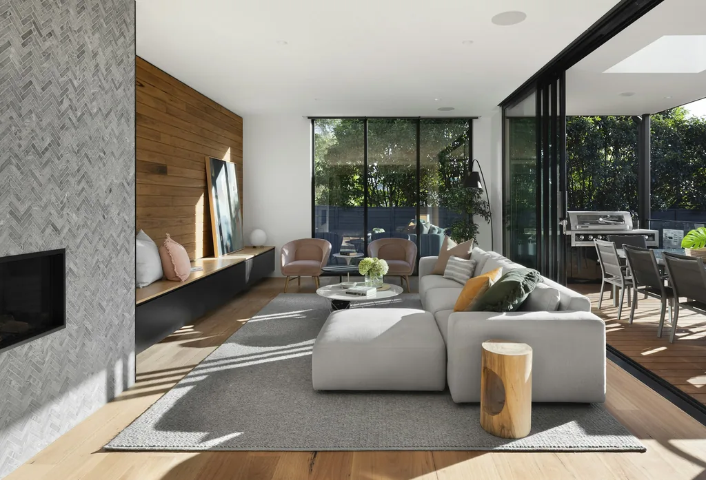 Modern living room with oak paneling and floor-to-ceiling glass walls open to the patio